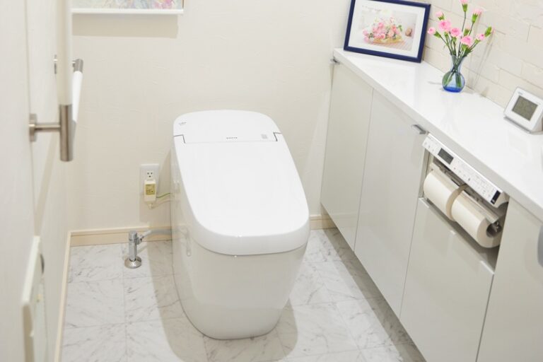 タンクレストイレとキャビネット付き手洗い器ですっきりと仕上げたトイレ